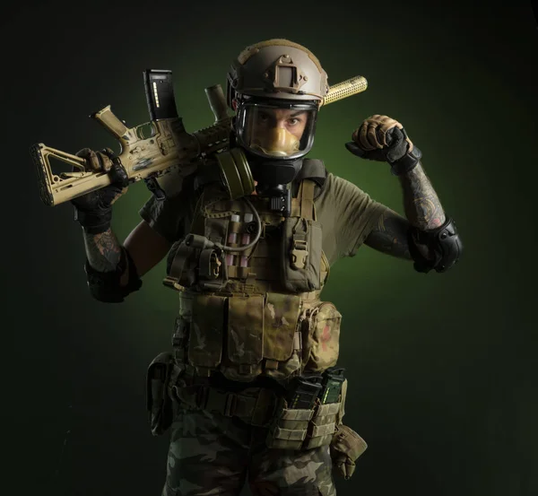Um tipo de roupa militar protectora e uma máscara de gás com uma espingarda. — Fotografia de Stock