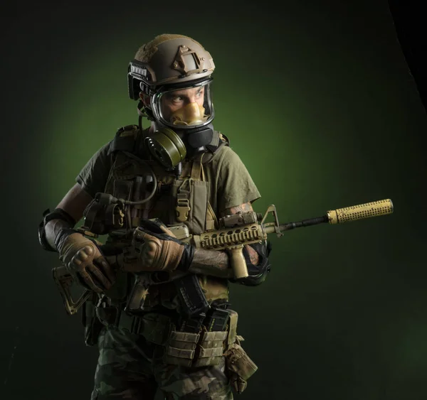 En kille i skyddande militära kläder och en gasmask med ett gevär — Stockfoto