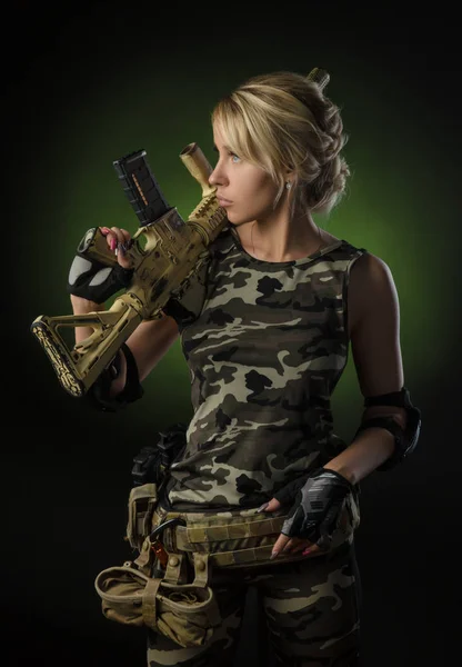 Schöne blonde Mädchen in Militärkleidung mit einem Gewehr in den Händen — Stockfoto
