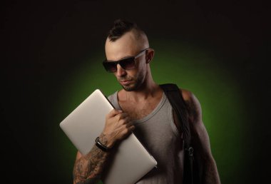 dizüstü bilgisayar ile adam gözlük ve bir t-shirt ile kameraya bakarak poz