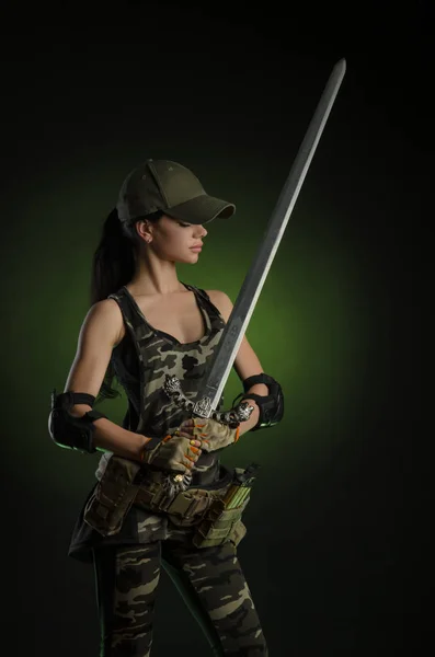 The girl in military special clothes posing with a gun in his hands on a dark background in the haze — Stock Photo, Image