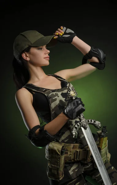 The girl in military special clothes posing with a gun in his hands on a dark background in the haze — Stock Photo, Image