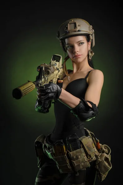 Das Mädchen in militärischer Spezialkleidung posiert mit einem Gewehr in der Hand vor dunklem Hintergrund im Dunst — Stockfoto