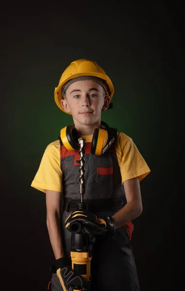 Barn byggaren kostym poserar med ett arbetsredskap — Stockfoto
