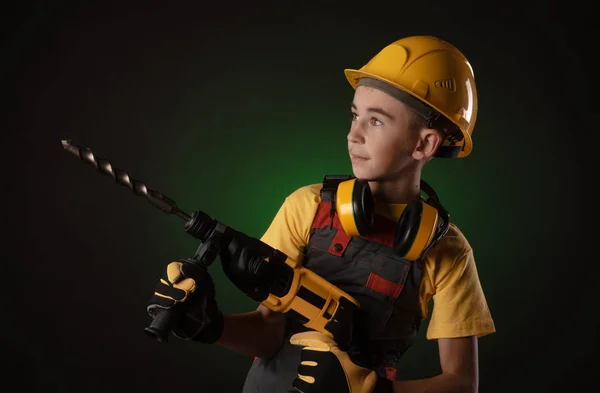 Criança o traje Construtor posando com uma ferramenta de trabalho — Fotografia de Stock