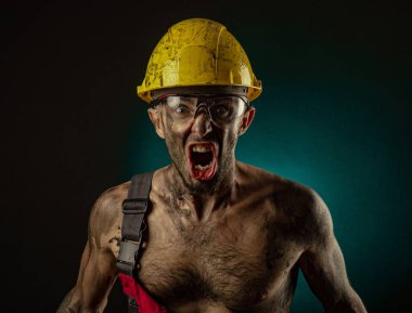 Bir işçi nin kıyafetleri ve bir kask, kirli, is, çıplak bir vücut, kamera grimaces ile bir adam madenci