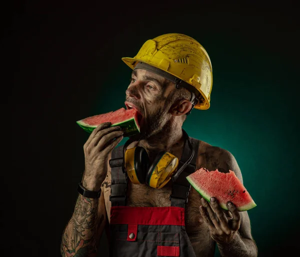 Retrato de un feliz minero sonriente comiendo sandía para el almuerzo — Foto de Stock