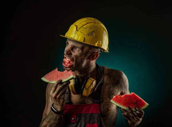 Retrato de un feliz minero sonriente comiendo sandía para el almuerzo — Foto de Stock