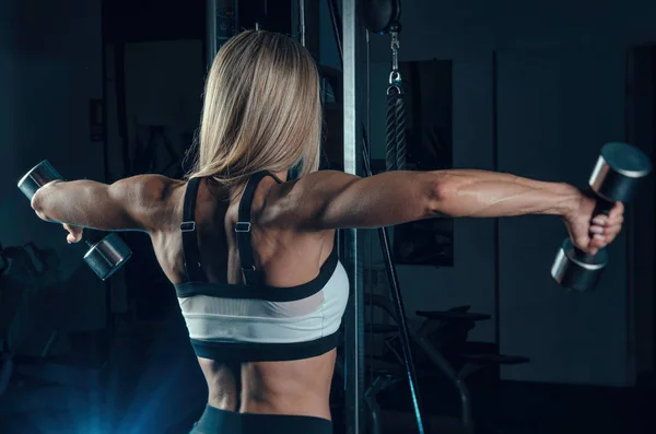 La chica atleta en ropa deportiva está entrenando en el gimnasio — Foto de Stock