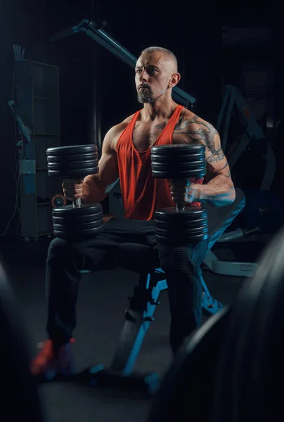 Fuerte musculoso hombre trenes en el gimnasio — Foto de Stock