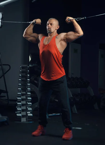 Fuerte musculoso hombre trenes en el gimnasio — Foto de Stock