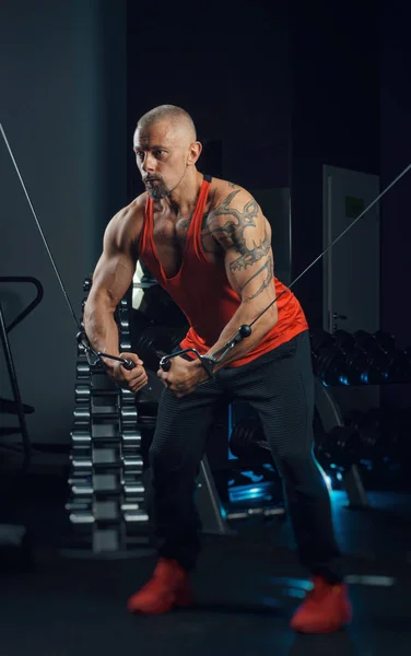 Fuerte musculoso hombre trenes en el gimnasio — Foto de Stock