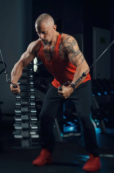 Fuerte musculoso hombre trenes en el gimnasio — Foto de Stock