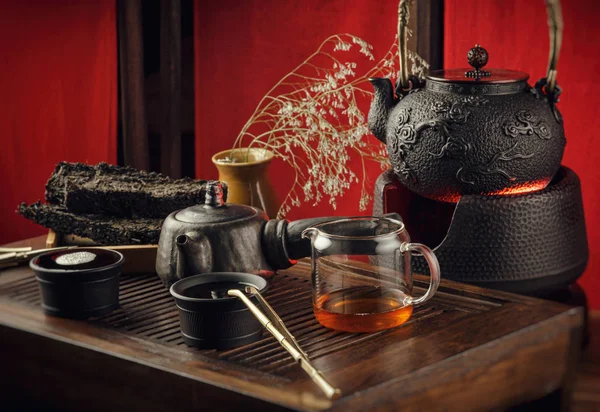 Чайный столик с инструментами чайники чашки блины и чай Шен Пуэр — стоковое фото
