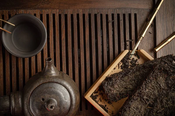 Tea table with instruments teapots cups pancake and tea Shen Puer — Stock Photo, Image