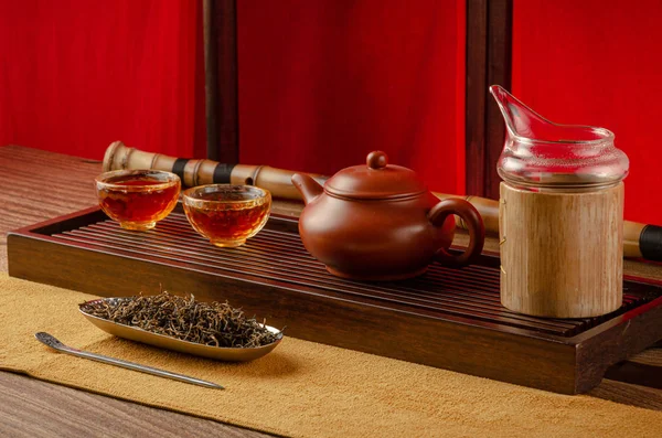 Tea table with instruments teapots cups pancake and tea Shen Puer — Stock Photo, Image