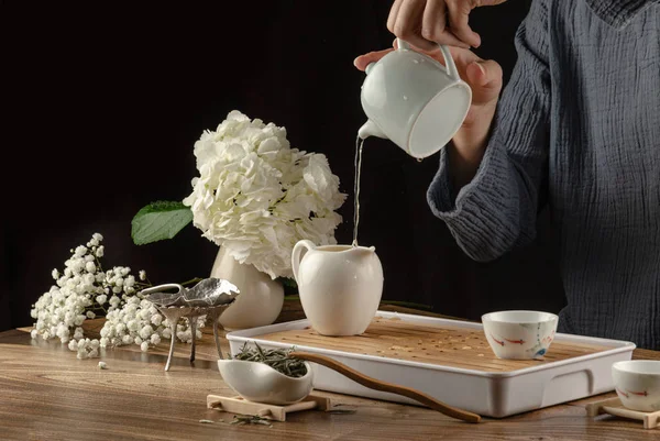 Čajový stůl s nástroji teapoty šálky a zelený čaj — Stock fotografie