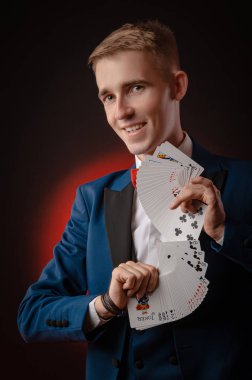 Genç bir sihirbaz elinde kartları tutuyor