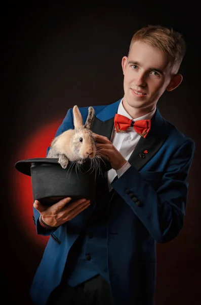 Mladý kluk kouzelník iluzionista drží klobouk s králíkem — Stock fotografie