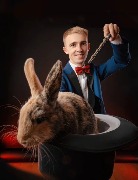 Mladý kluk kouzelník iluzionista drží klobouk s králíkem — Stock fotografie