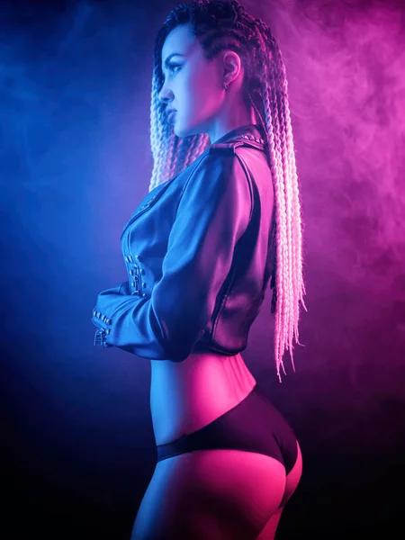 Neon ışıkta poz veren uzun saçlı güzel seksi kız.