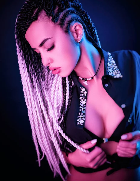 Bella ragazza sexy con lunghi dreadlocks posa in luce al neon — Foto Stock