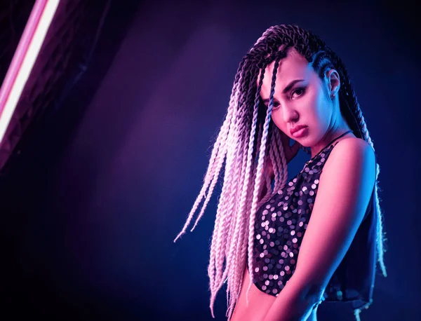 Neon ışıkta poz veren uzun saçlı güzel seksi kız.