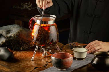 Çay seremonisi, cam çaydanlıkta ateş yakıyor.