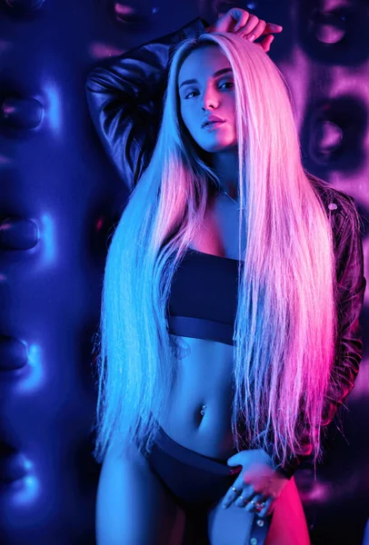 Vacker elegant fashionabla flicka i bodysuit poserar i foto Studio på mörk bakgrund i neon ljus — Stockfoto