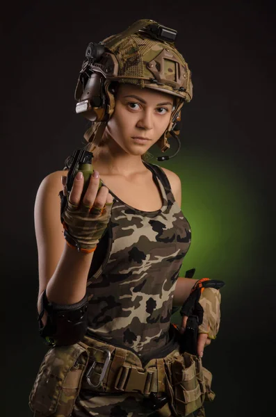 Girl in military uniform and helmet holding a grenade — Stock Photo, Image