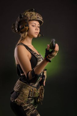Askeri üniformalı ve miğferinde el bombası olan bir kız.