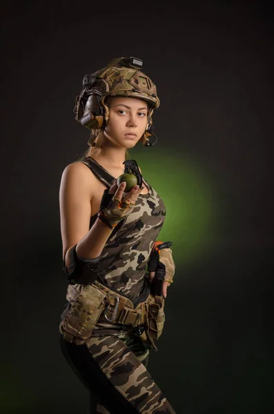 Menina em uniforme militar e capacete segurando uma granada — Fotografia de Stock