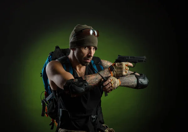 Homem com arma e mochila no fundo escuro — Fotografia de Stock