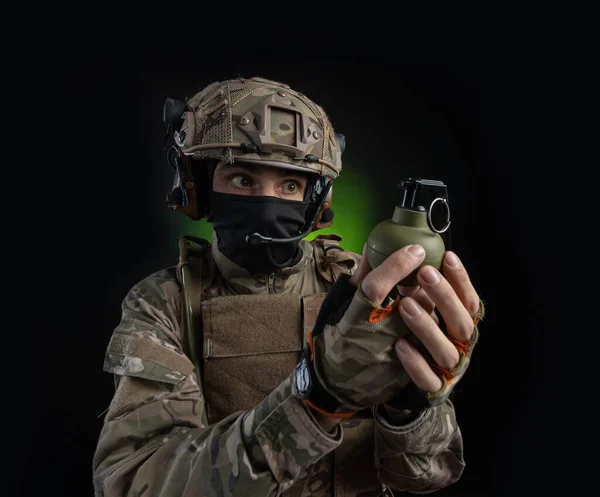 Un soldat en tenue militaire avec une arme sur fond sombre — Photo
