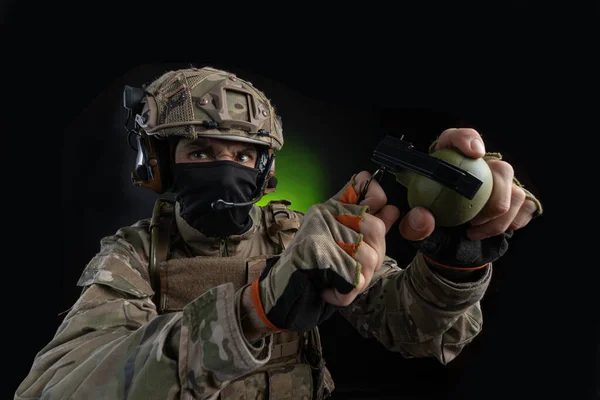 Um soldado masculino em roupas militares com uma arma em um fundo escuro — Fotografia de Stock