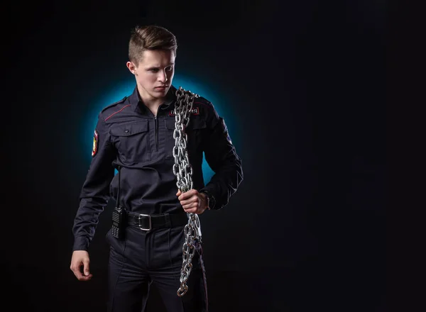 Een knappe man in een politie-uniform met een grote ketting om zijn schouder. gevangenisdirecteur. Engelse vertaling Politie — Stockfoto