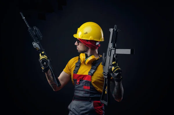 Мужчина в форме строителя в каске с мягким оружием в руках — стоковое фото