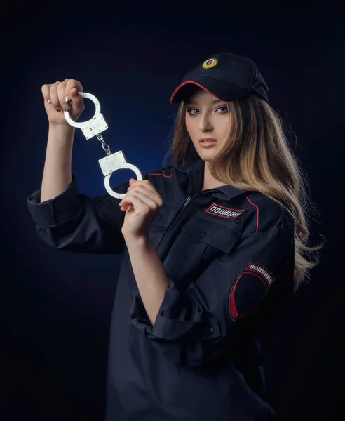 Girl in police uniform with a gun-Russian police officer with handcuffs. English translation of Police — Stock Photo, Image