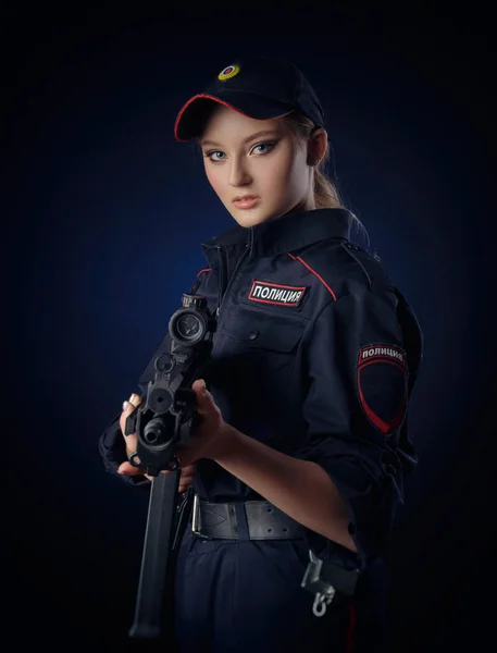 La chica en el uniforme de policía con un arma es un policía ruso con arma. Traducción española de Police — Foto de Stock