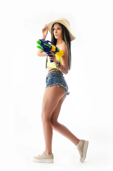 Brunette fille avec un pistolet à eau en vêtements d'été, mince et sexy — Photo