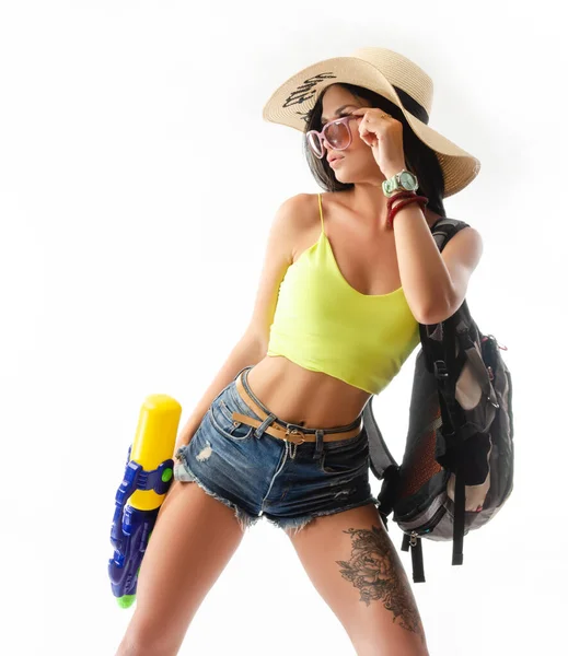 Ragazza bruna con una pistola ad acqua in vestiti estivi, sottile e sexy — Foto Stock