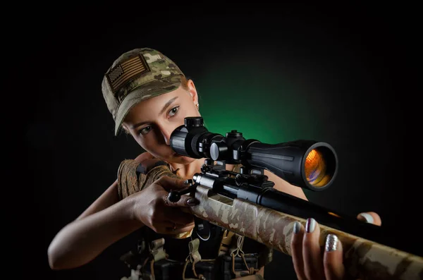 Seksowna dziewczyna w wojskowym airsoftowym kombinezonie z karabinem snajperskim na ciemnym tle — Zdjęcie stockowe