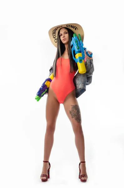 Брюнетка дівчина з водяним пістолетом в літньому одязі, струнка і сексуальна — стокове фото