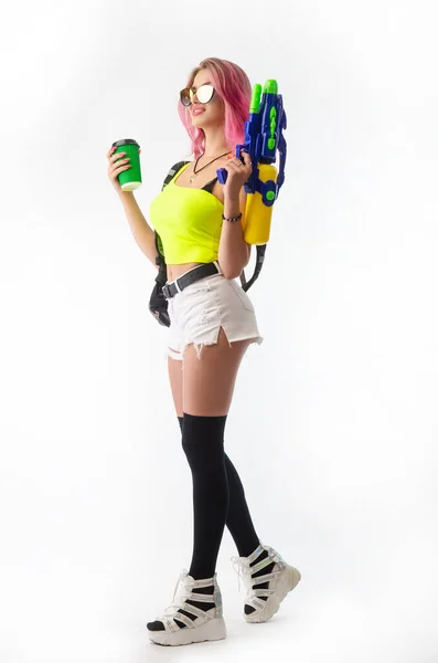 Девушка с водяным пистолетом в летней одежде, стройная и сексуальная изолированы на белом фоне — стоковое фото