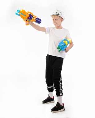 Beyaz arka planda su tabancası olan çocuk.