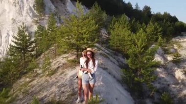 Güzel yaz elbiseli ve şapkalı kızlar tebeşir dağları boyunca yürür.