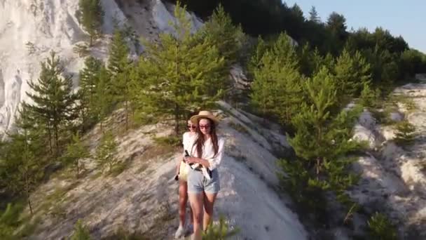 Chicas en hermosos vestidos de verano y sombreros caminan a lo largo de las montañas de tiza — Vídeos de Stock