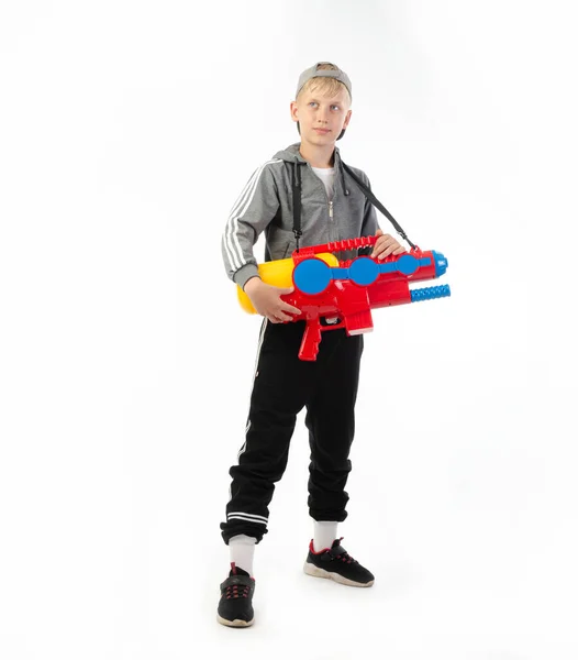 Ein Junge mit einer Wasserpistole auf weißem Hintergrund — Stockfoto