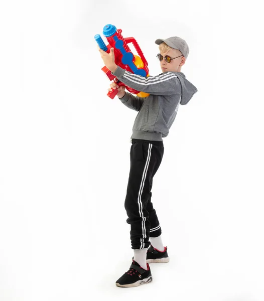 Ein Junge mit einer Wasserpistole auf weißem Hintergrund — Stockfoto