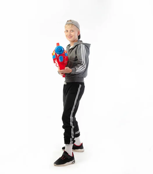 Un niño con una pistola de agua aislada sobre un fondo blanco — Foto de Stock